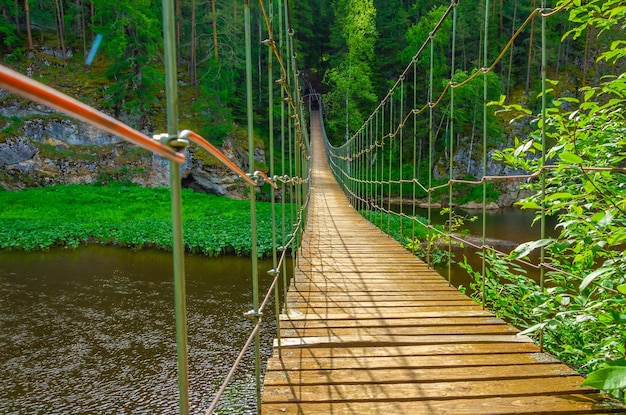 Hängende Holzbrücke über den Fluss.