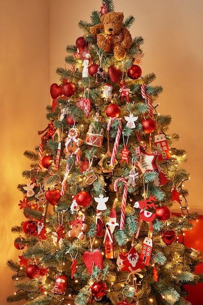 Hängende Weihnachtsdekoration. Weihnachtsbaum Verzierter Baum des neuen Jahres auf unscharfer, funkelnder und feenhafter Wand Neujahrsgruß-Karten-Schablone Weihnachtswand Weihnachtsspielwaren und -dekorationen.