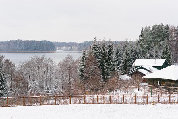 Häuser unter Schnee in der Nähe eines Sees im Winter