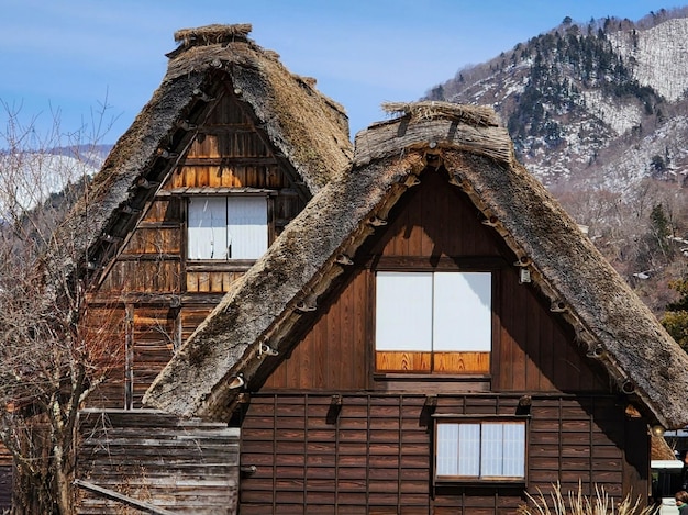 Foto häuserzeilen mit strohdächern mit eisbergen im hintergrund in shirakawago