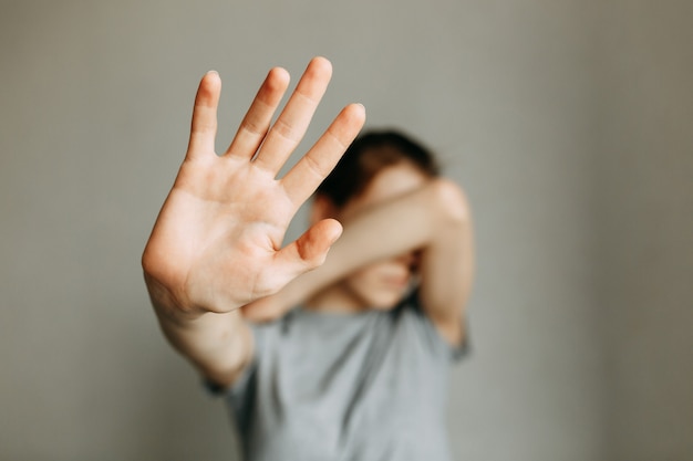 Häusliche Gewalt gegen Frauen Das Mädchen bedeckt ihr Gesicht mit der Hand und bittet um Hilfe