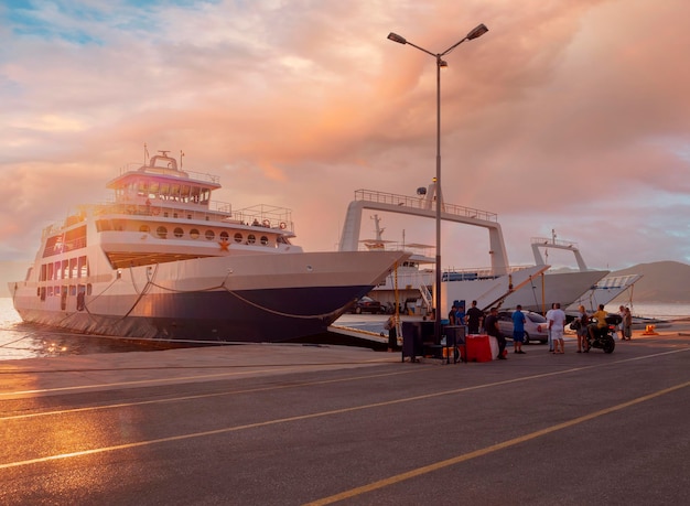 Hafen mit Fähre bei Sonnenuntergang in einem Kurort Loutra Edipsou auf der griechischen Insel Euböa in Griechenland