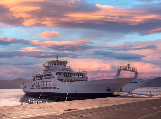 Hafen mit Fähre bei Sonnenuntergang in einem Kurort Loutra Edipsou in Griechenland