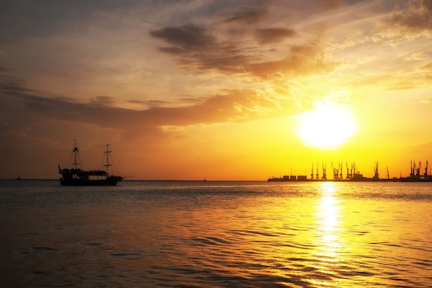 Hafen von Berdjansk bei Sonnenuntergang. Schiffssegeln auf dem Meer zum Ufer bei Sonnenaufgang.