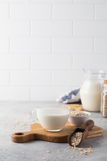 Haferflocken-Gemüsemilch in einem Becher auf dem Tisch mit Haferflocken in einer Schüssel