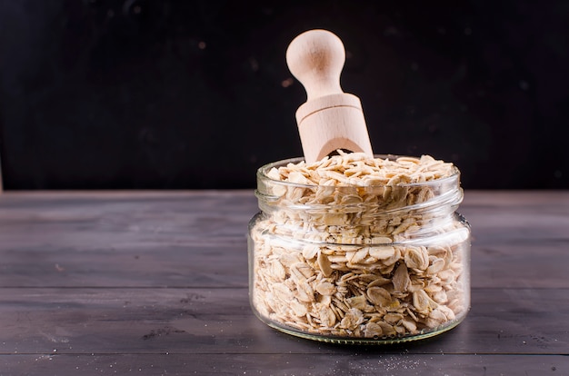 Haferflocken im Glas und im Holzlöffel