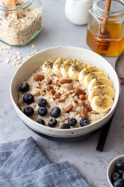 Haferflocken mit Banane Blaubeeren Mandeln und Honig Gesundes Essen Vegetarisches Essen Frühstück