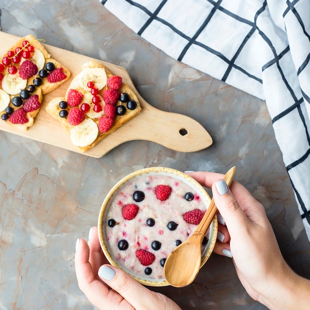 Haferflocken mit Beeren und Sandwiches mit Erdnussbutter, Banane, Johannisbeere und Himbeeren