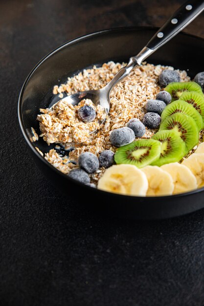 Haferflocken Obst Frühstück Milch Banane Kiwi Beeren Blaubeer Mahlzeit Snack auf dem Tisch