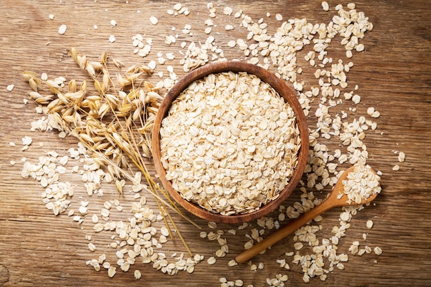 Haferflocken und Haferohren auf Holztisch