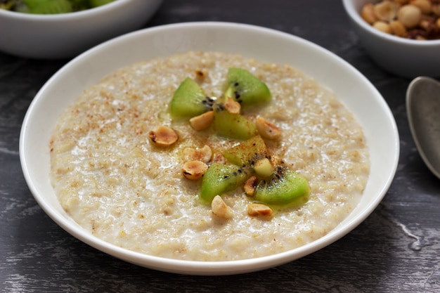 Haferflockenfrühstück mit Butter, Kiwi, Haselnüssen und Zimt.