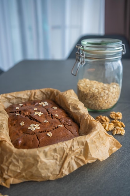 Haferflockenkuchen mit Bananen und Walnüssen auf dunkelgrauem Hintergrund in der heimischen Küche