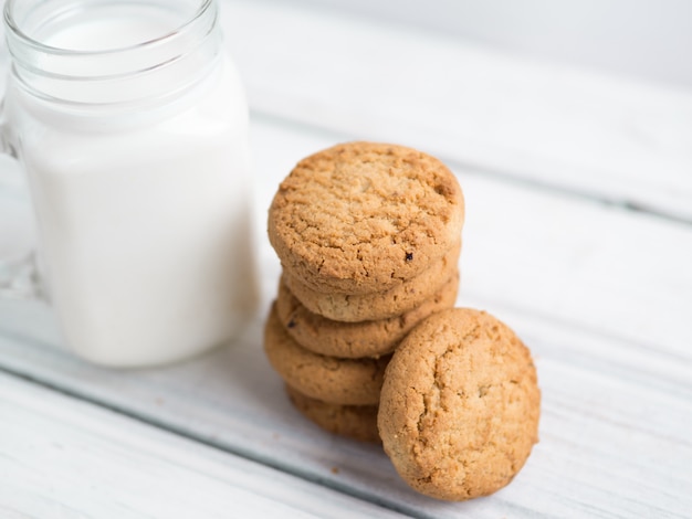 Haferflockenplätzchen mit Milch auf hölzernem Hintergrund