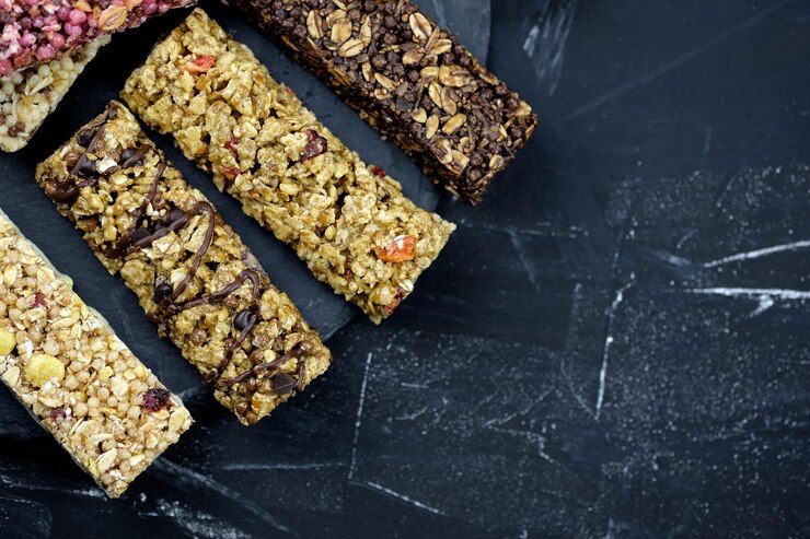 Haferflockenriegel mit Beeren und Cornflakes. Gesunde nahrhafte Snacks. Fitness-Bars auf schwarzem Hintergrund Draufsicht mit Platz für Text.