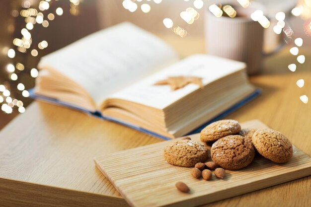 Haferkekse, Mandeln und Buch auf dem Tisch zu Hause