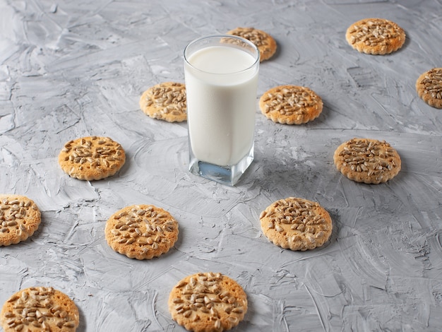 Haferkekse und ein Glas Milch auf grauem Betonhintergrund. Ansicht von oben