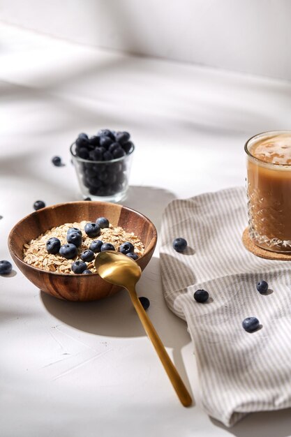 Hafermehl mit Blaubeeren, Löffel und Kaffee
