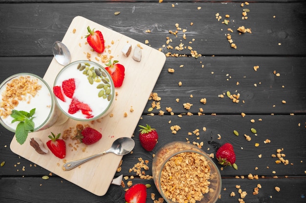 Hafermehl mit Joghurt und Beeren auf einem schwarzen hölzernen Hintergrund.