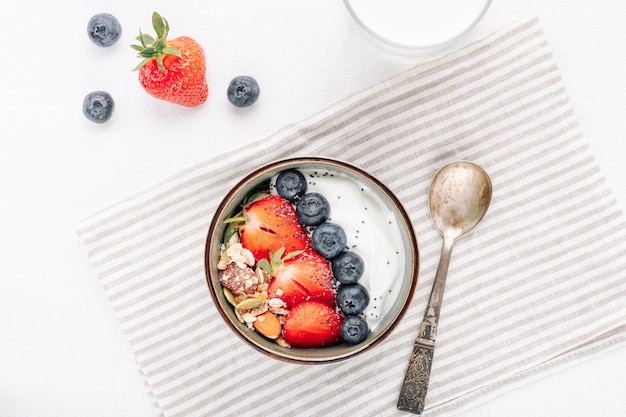 Hafermüsli mit Joghurt und frischen Beeren in einer Schüssel für eine gesunde Frühstücksdraufsicht