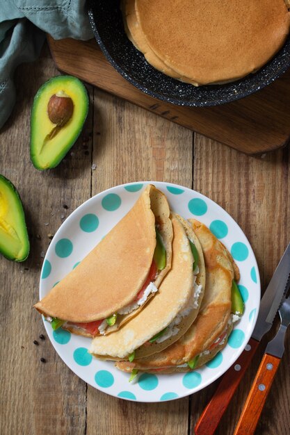 Haferpfannkuchen gefüllt mit Hüttenkäse, Lachs und Avocado in einem Teller Ansicht von oben