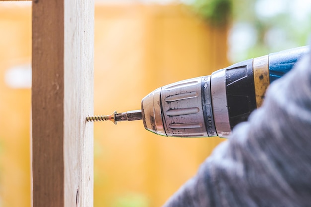 Hágalo usted mismo Home Handyman está usando un destornillador inalámbrico para atornillar