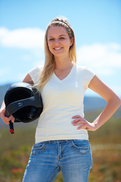 Hagamos esto Captura recortada de una bella joven al aire libre posando con un casco de paracaidismo bajo el brazo