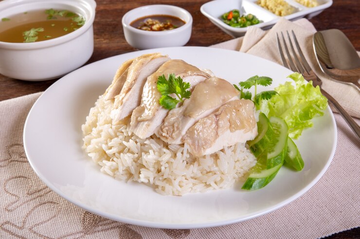 hainanese arroz de frango cozido na mesa de madeira
