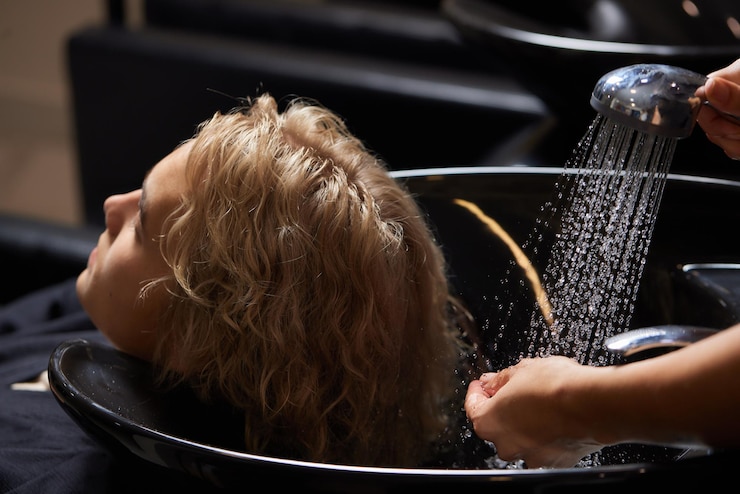 Foto hairstylist friseur waschen kundenhaar junger mann entspannt sich im friseur schönheitssalon