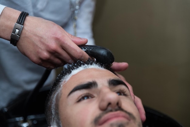 Hairstylist Friseur waschen Kundenhaar Junger Mann entspannt sich im Friseur Schönheitssalon