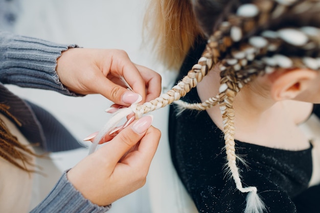 Hairstylist geflochtene Afro-Zöpfe Zöpfe Haare der Kundin im Friseursalon