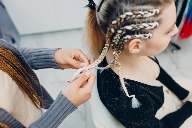 Hairstylist geflochtene Afro-Zöpfe Zöpfe Haare der Kundin im Friseursalon