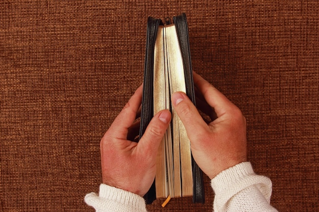 Halb geöffnete Bibel in seiner Hand