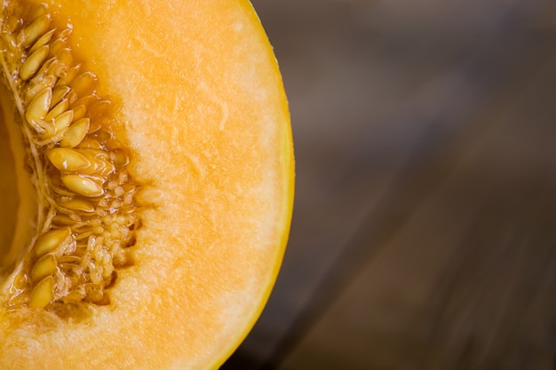 Halbe Melone auf einem dunklen hölzernen Hintergrund