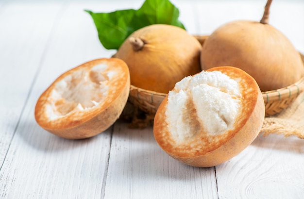 Halbes Santol auf Holzhintergrund Santol hat einen sauren Geschmack und das mittlere Santol ist süßer