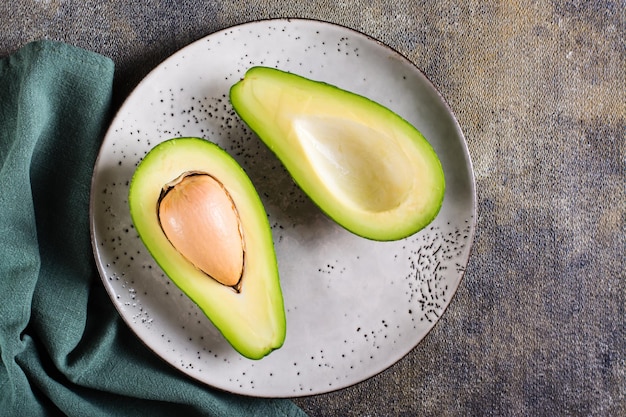 Halbieren Sie frische Avocado auf einem Teller auf dem Tisch Gesundes Essen Draufsicht