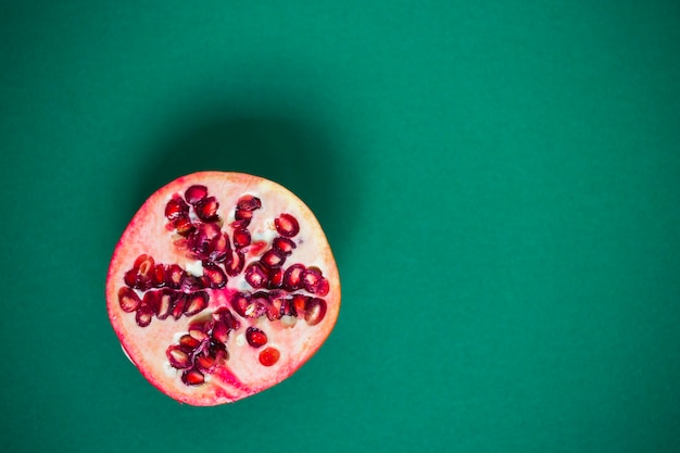 Halbierter Granatapfel auf grünem Hintergrund