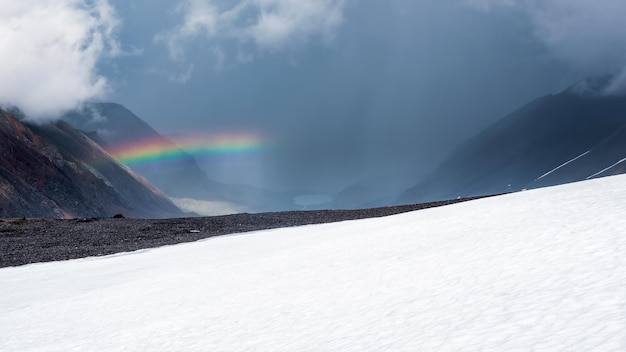 Halfrainbow sobre o vale da montanha do rio tyute arco-íris sobre um vale da montanha de neve paisagem alpina panorâmica com montanhas nevadas com arco-íris em tempo chuvoso e ensolarado altai