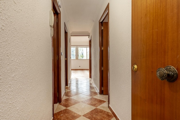 Hall de entrada de una casa residencial urbana ajedrezado suelos de gres y puertas de acceso a otras habitaciones