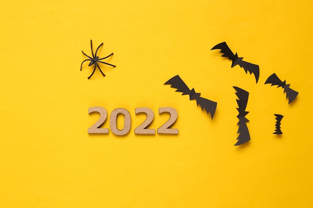 Halloween 2022 Murciélagos arañas y 2022 sobre fondo amarillo