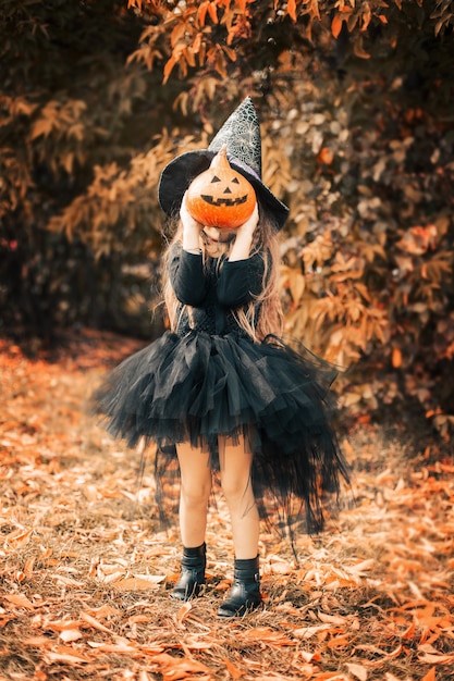 Halloween, a garota ri e segura uma abóbora nas mãos