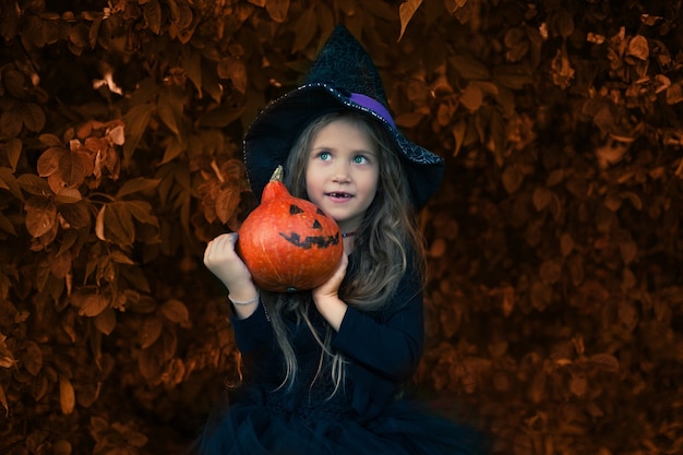 Halloween, a garota ri e segura uma abóbora nas mãos