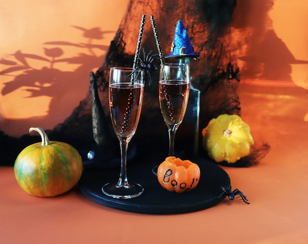 Halloween bebe vino calabazas arañas y decoración mística sobre un fondo naranja brillante