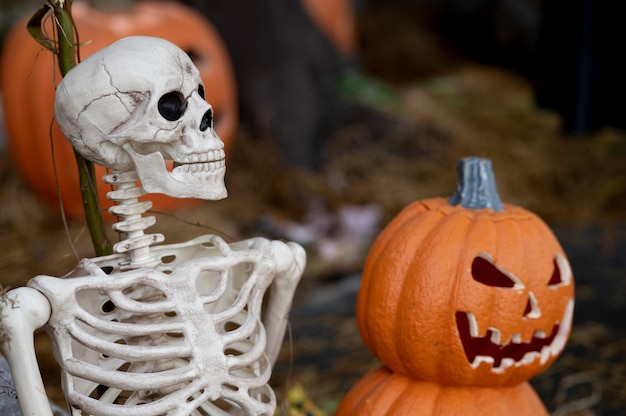 Halloween com abóbora e conceito de esqueleto em segundo plano.