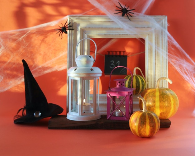 Halloween eine Laterne mit einer brennenden Kerze Kürbisse ein Hexenhut der Innendekoration