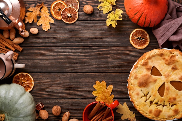 Halloween-Essen. Hausgemachter Kürbiskuchen oder Torte mit einem gruseligen Gesicht für Halloween auf einem Holztisch. Platz kopieren. Halloween-Food-Konzept.