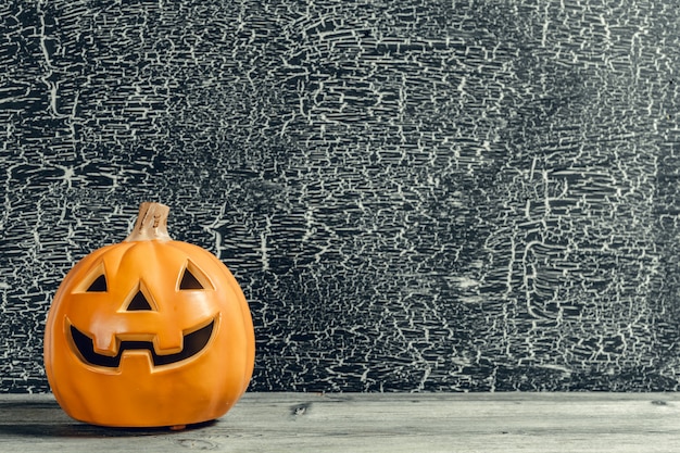 Halloween-Feiertagshintergrund mit Kürbis auf Holztisch