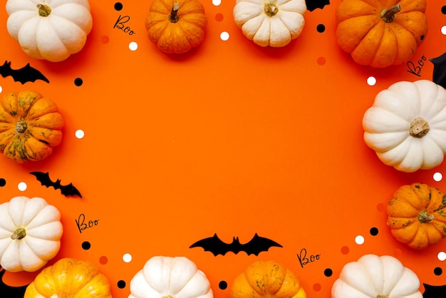 Halloween flache Laienzusammensetzung aus schwarzen Papierfledermäusen fand Kürbisse auf orangefarbenem Hintergrund Halloween-Konzept