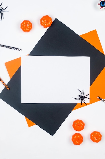 Halloween-Flachlage-Komposition mit Kürbissen trinken Strohhalme Spinnen Konfetti Leckereien