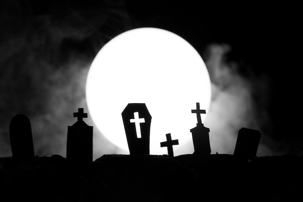 Halloween-Friedhof mit Gräbern auf dem Hintergrund des Mondes mit Nebel