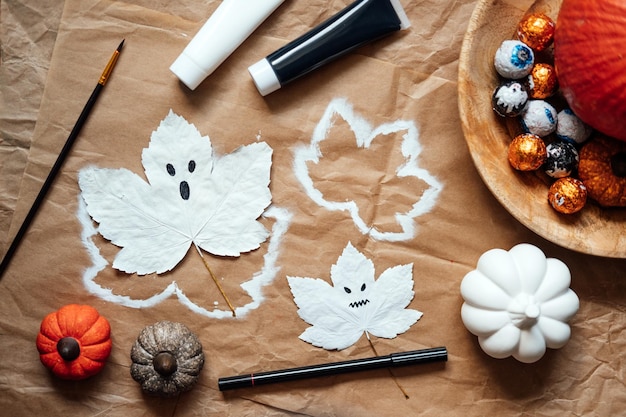 Foto halloween-geister aus trockenen ahornblättern halloween-natur-diy-deko kinderkunstprojekt nachhaltig